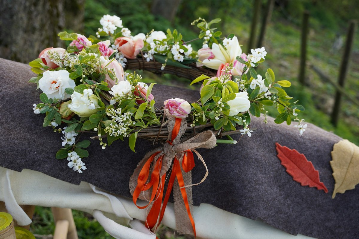 Casket spray of white and pink roses with greenery and ribbon resting on a casket